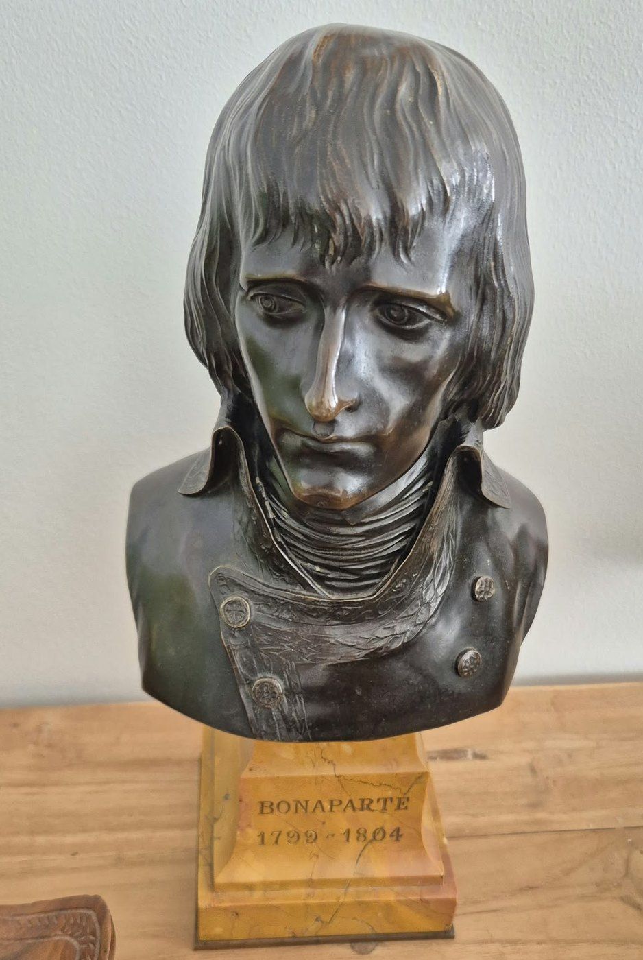 Buste de Bonaparte en métal sombre, sur un socle jaune gravé « Bonaparte 1799-1804 »