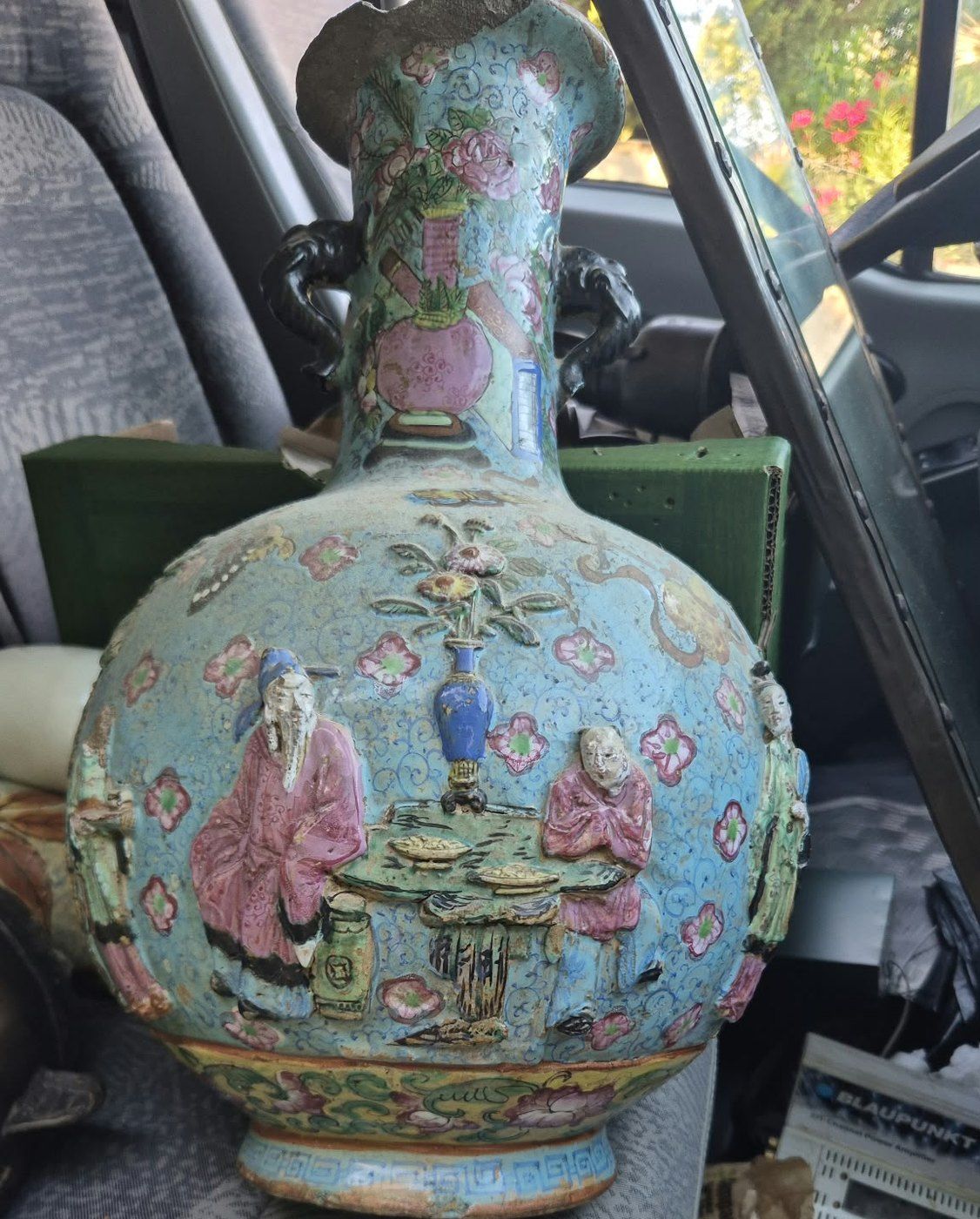 Vase pansu à décor de personnages et de fleurs en relief, sur fond bleu turquoise