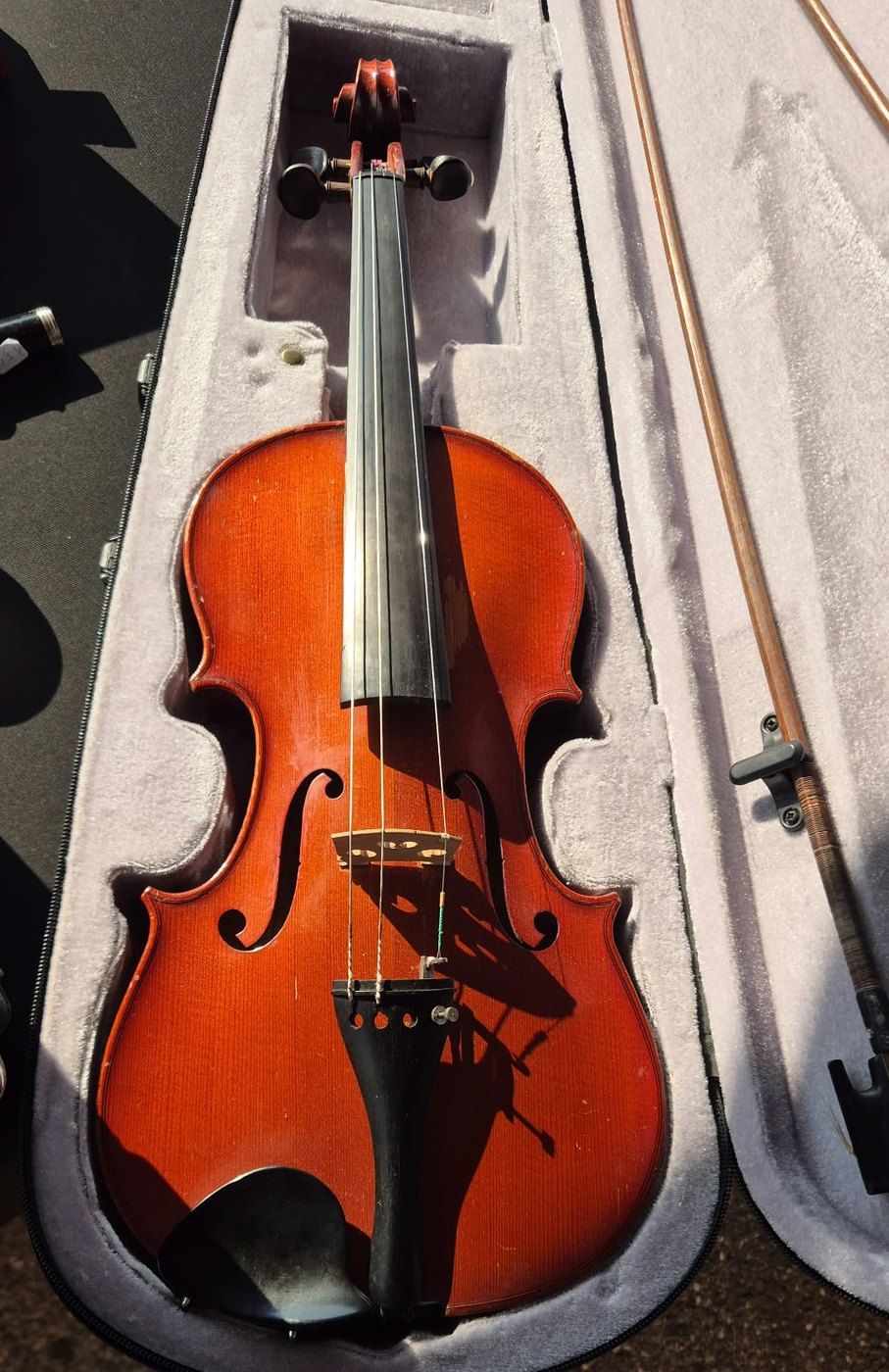 Violon au vernis rouge dans son étui gris, avec son archet