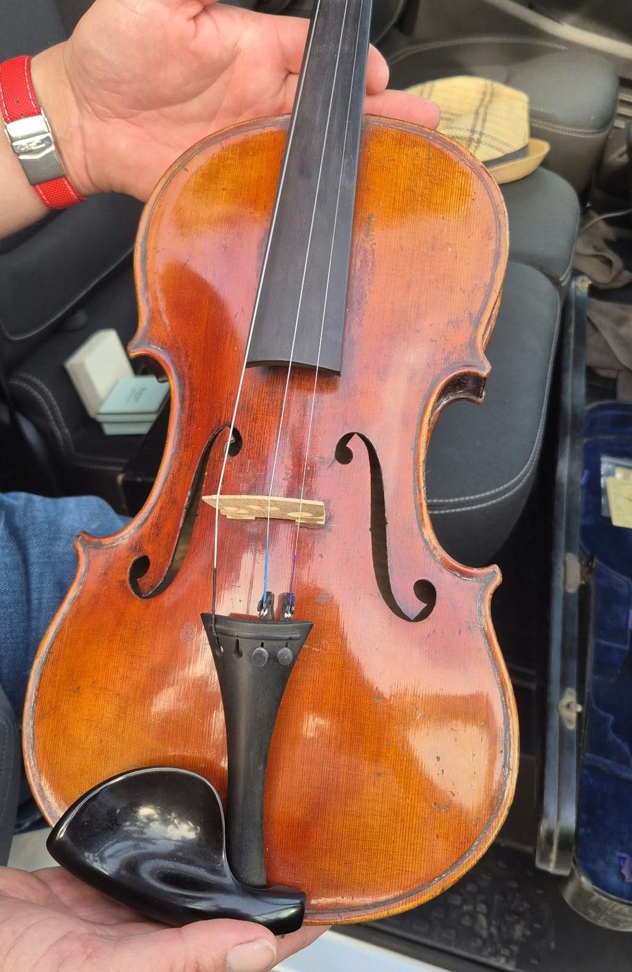 Violon au vernis orangé tenu à deux mains